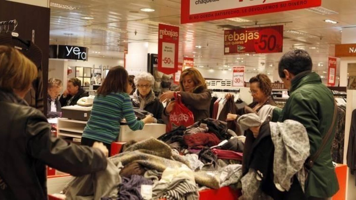 Varias personas en una tienda de ropa en rebajas.-EL PERIÓDICO