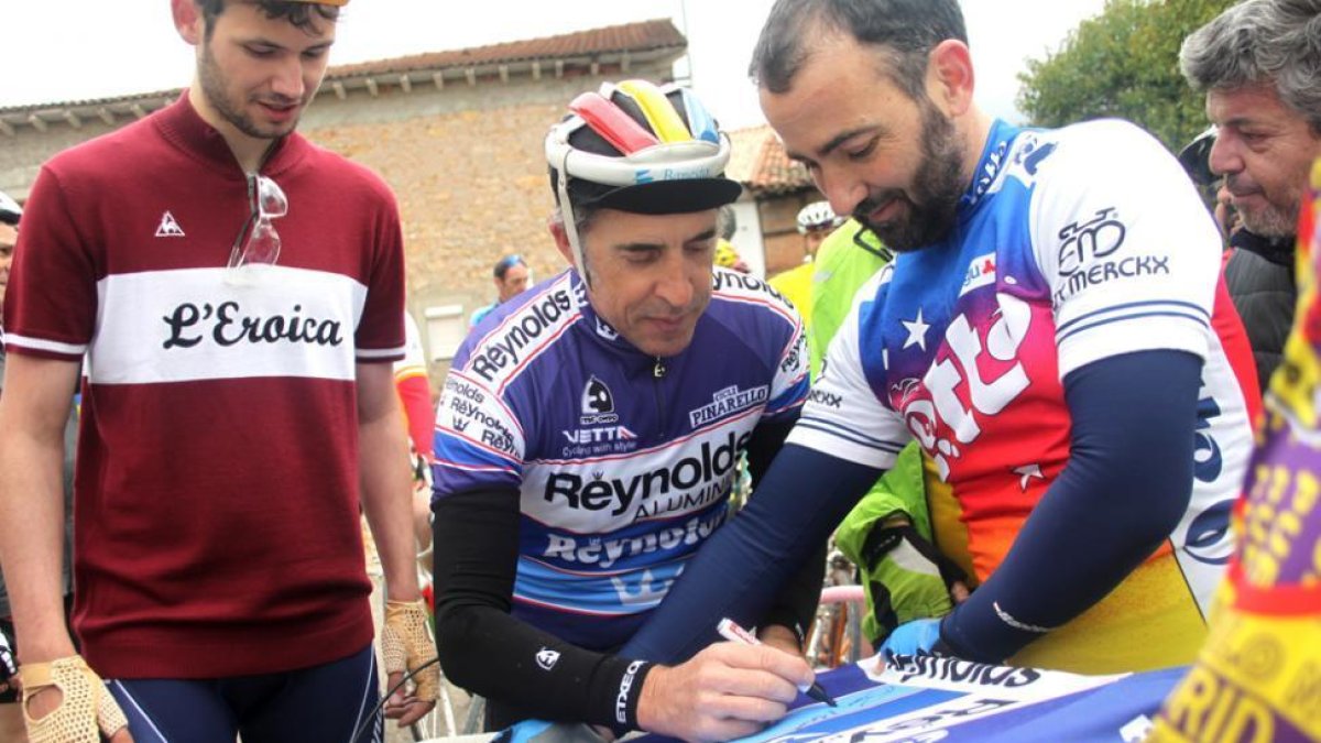 Perico Delgado firma una camiseta del Reinolds a un participante.-DIEGO MAYOR