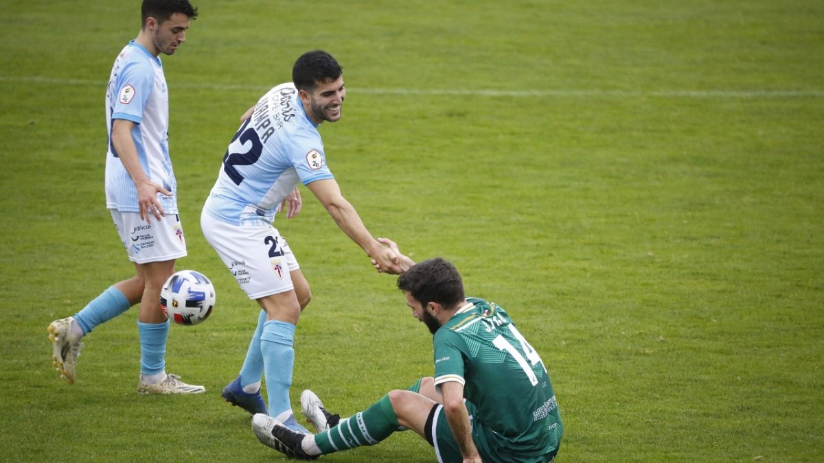 Juampa Barros, con el dorsal 22, tiende la mano a un rival que está en el suelo. El Correo Gallego