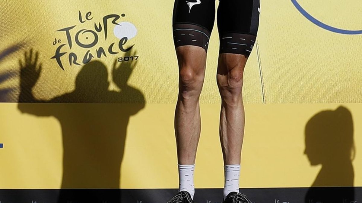 Las piernas de Chris Froome, en el podio durante la última edición de la ronda francesa que ganó.-GUILLAUME HORCAJUELO (EFE)