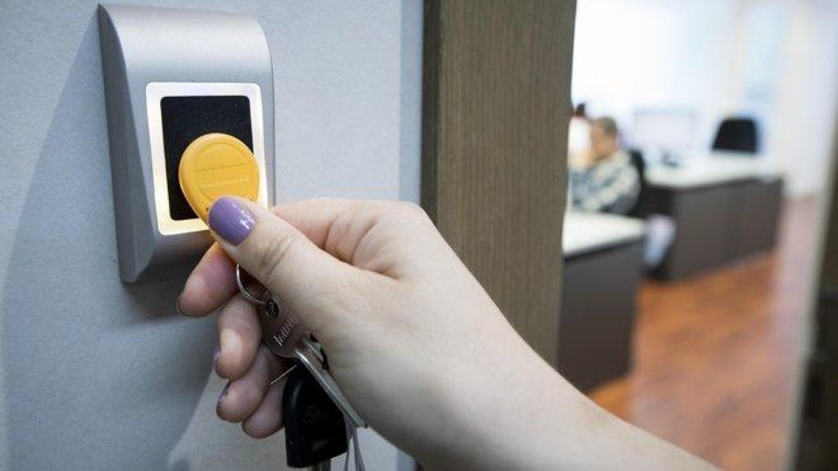 Una empleada utiliza una llave digital para fichar al comenzar y terminar su jornada laboral en unas oficinas.-FERRAN NADEU (EL PERIÓDICO)