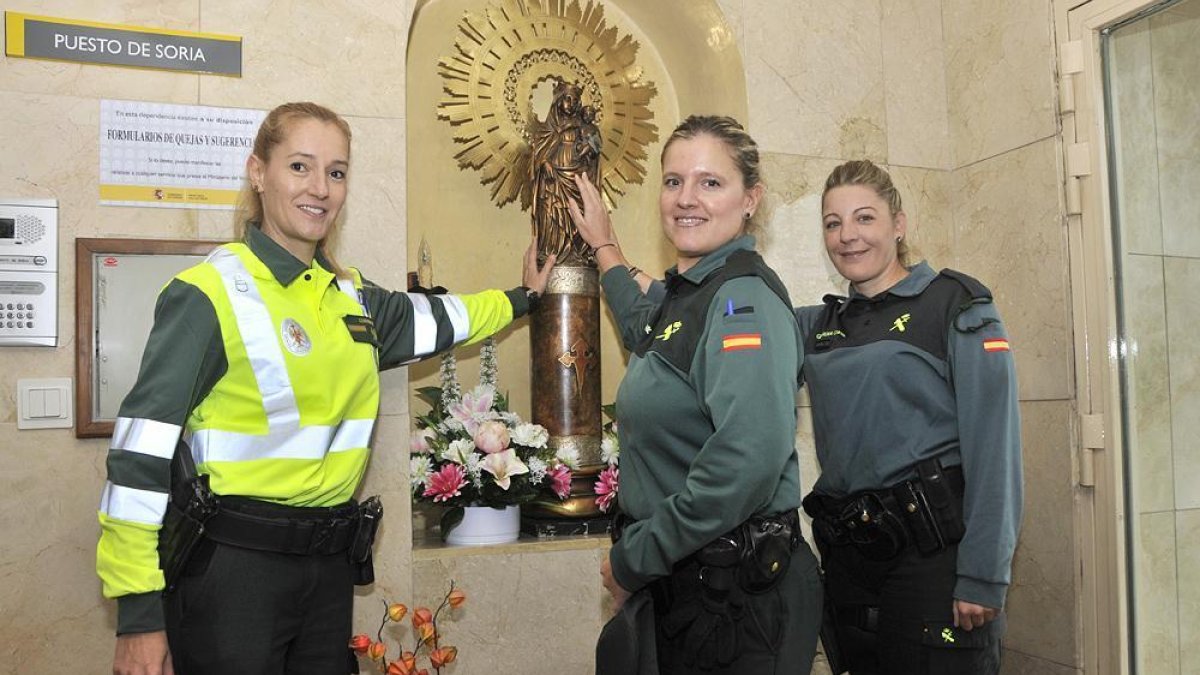 Raquel, Lorena y Marián junto a la Virgen del Pilar, patrona del Cuerpo, en la Comandancia de Soria.-VALENTÍN GUISANDE