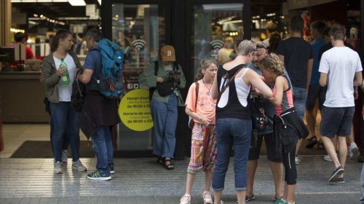 Turistas a las puertas de un supermercado.-ALBERT BERTRAN