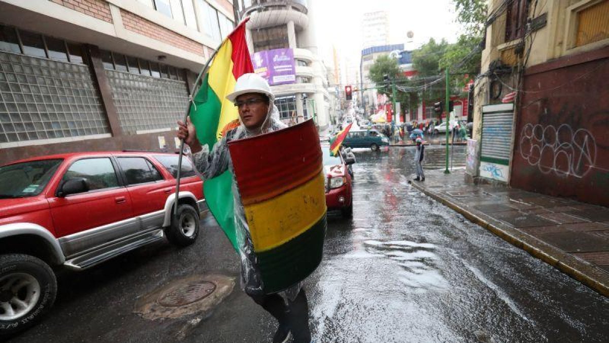 Un ciudadano contrario al expresidente Evo Morales marcha este domingo con un escudo improvisado en La Paz (Bolivia).-EFE