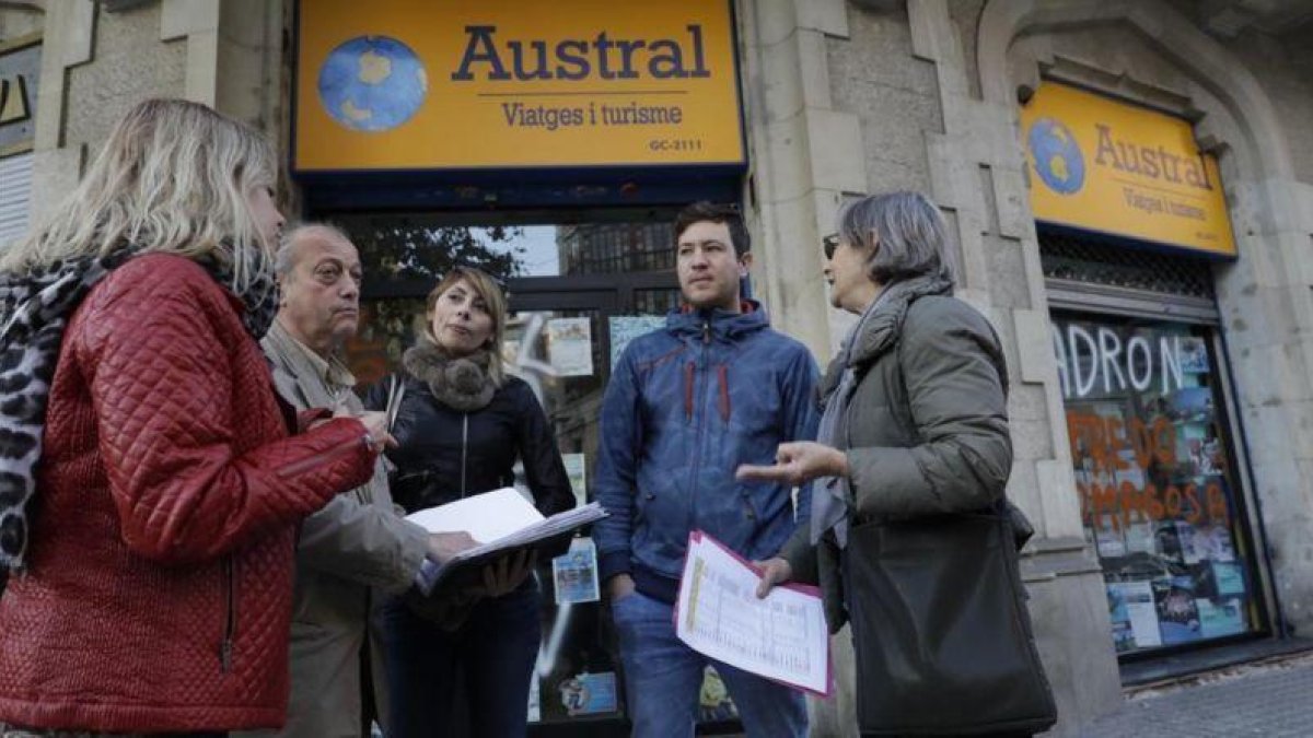 Afectados por el cierre de Austral Viatges ante la oficina cerrada, esta tarde.-FERRAN NADEU