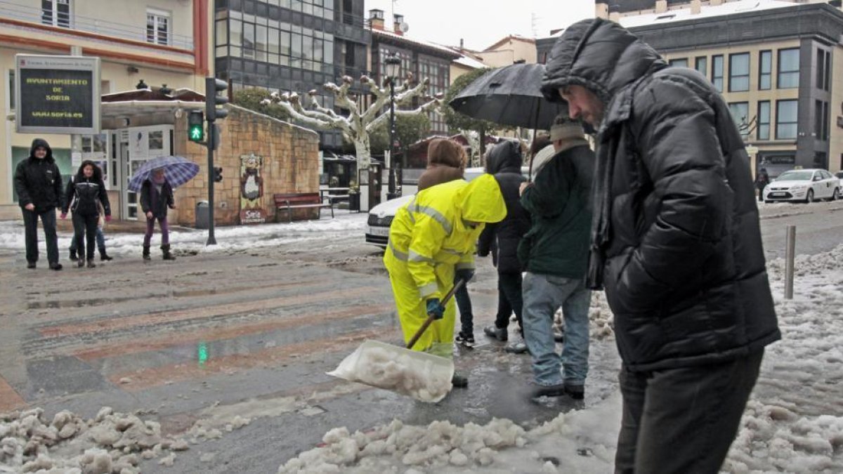 Un operario retira nieve en el centro de la capital con una pala.-MARIO TEJEDOR
