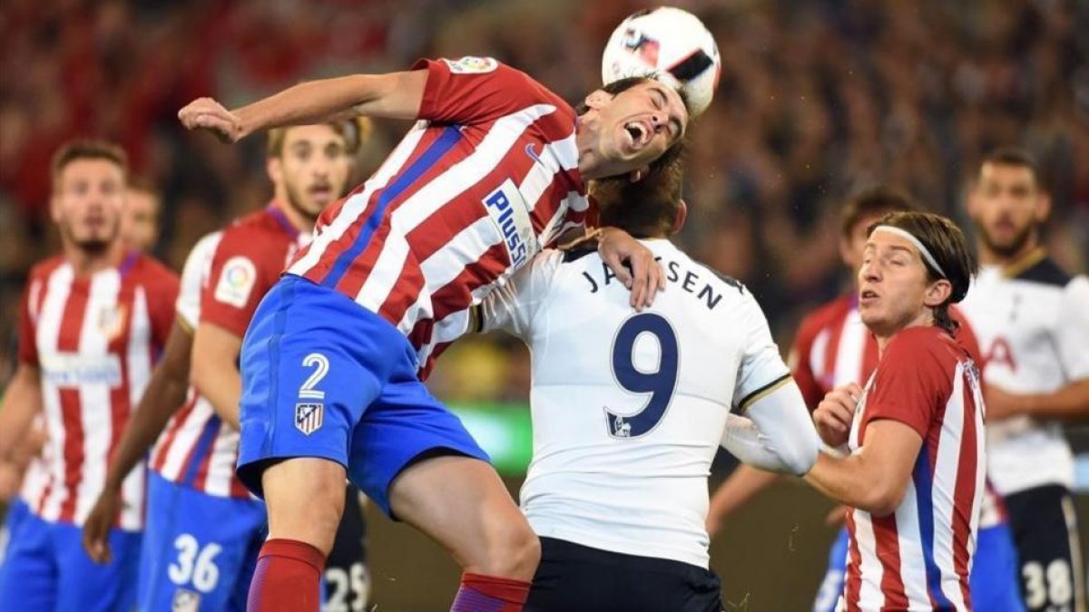 Godín, defensa uruguayo del Atlético, despeja un balón ante Janssen.-AFP / SAEED KHAN