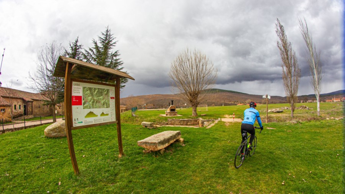 Un ciclista circula junto a una señal del GR86, Sendero Ibérico Soriano. MARIO TEJEDOR