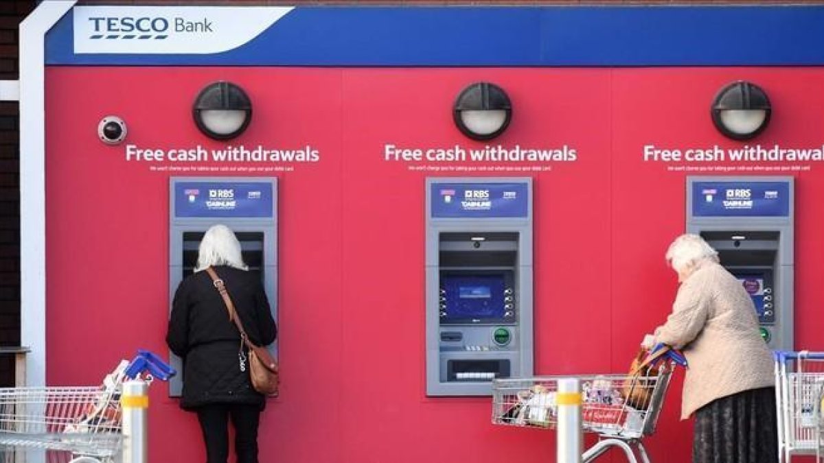 Dos mujeres retiran efectivo de cajeros automáticos de Tesco Bank en Liverpool.-PAUL ELLIS