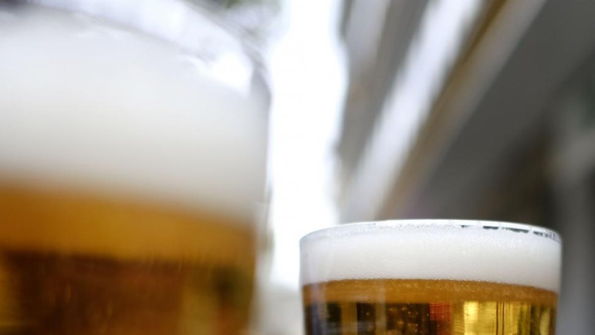 Dos consumidores de cerveza levantan su vaso.-ENRIQUE CARRASCAL