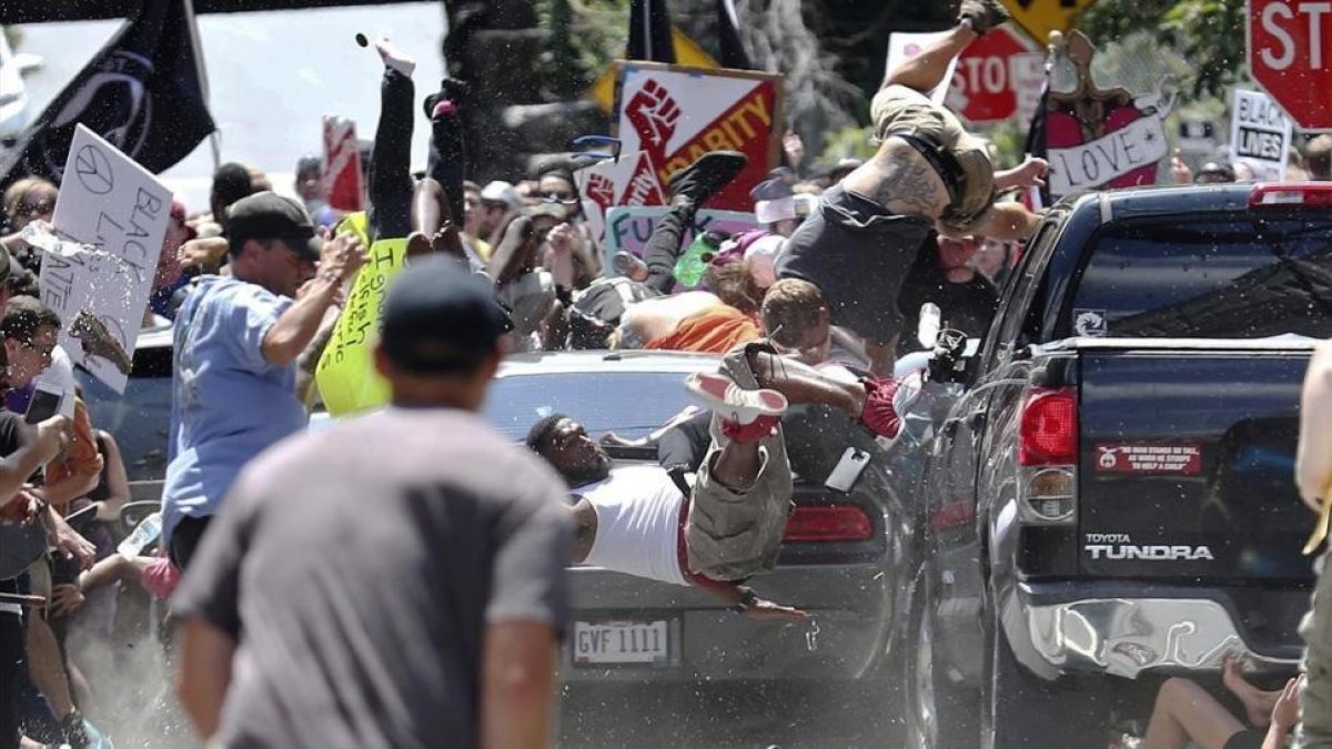Manifestantes vuelan por los aires cuando un vehículo arrolla a un grupo que se manifiestaban en contra de los blancos-nacionalistas en Charlottesville.-RYAN M KELLY