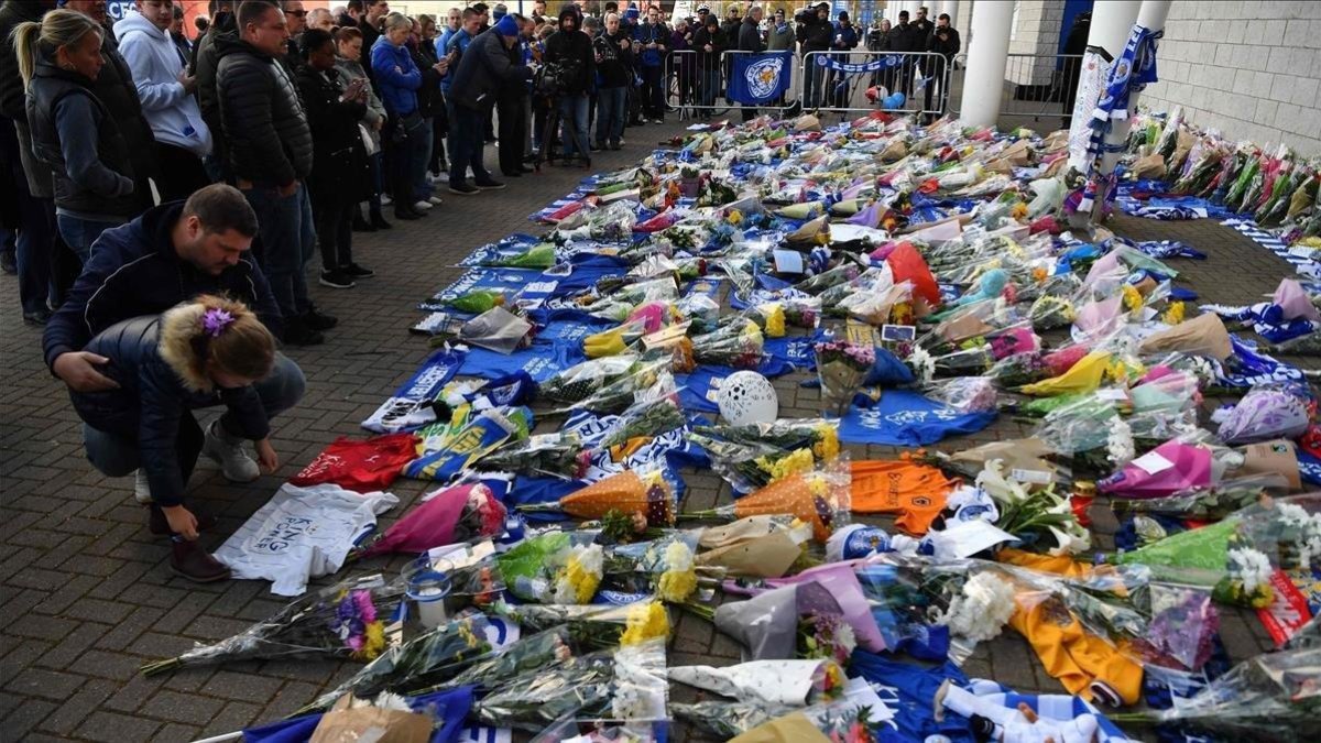 Aficionados y simpatizantes del Leicester dejan flores y objetos en los alrededores del estadio tras el accidente del helicóptero en el que falleció Srivaddhanaprabha, dueño del club.-AP
