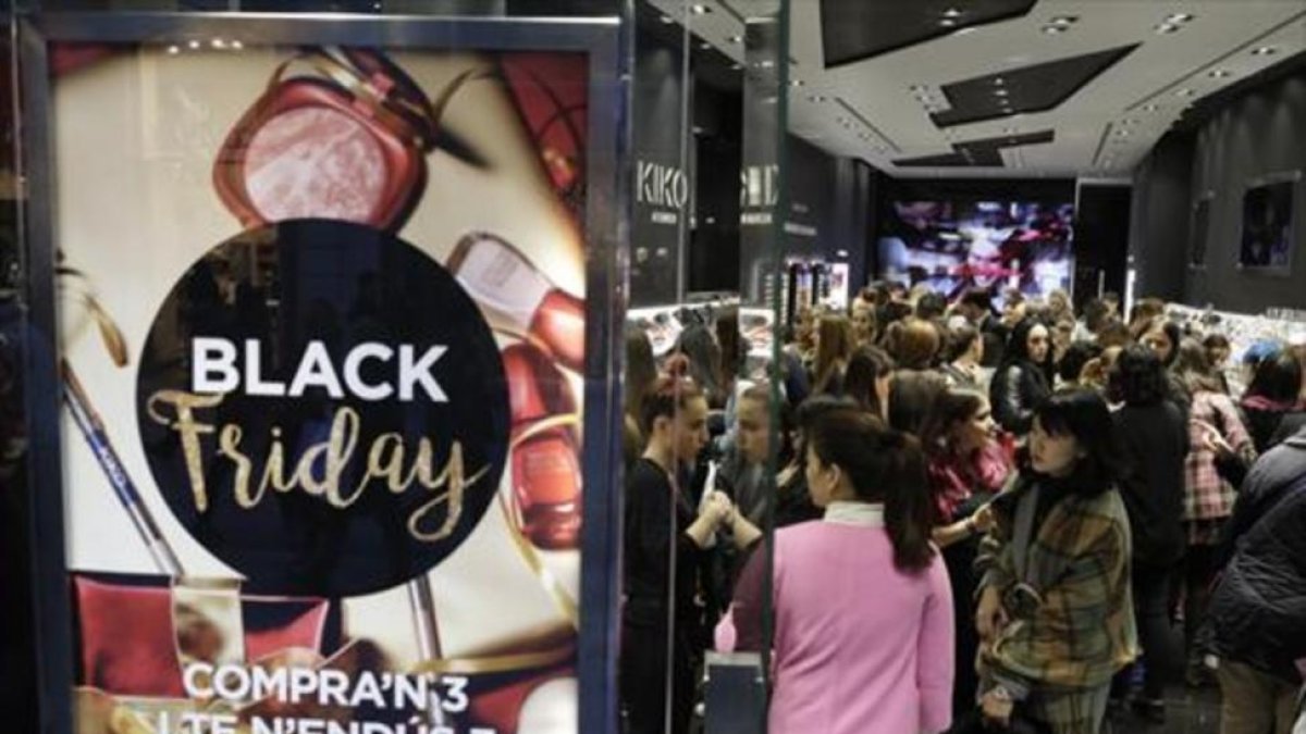 Dos mujeres cargan las bolsas con las compras realizadas el Black Friday .-FERRAN NADEU
