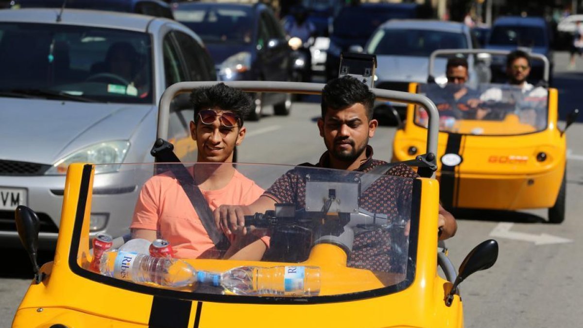 Turistas a bordo de los parlanchines vehículos de Go Car.-RICARD CUGAT