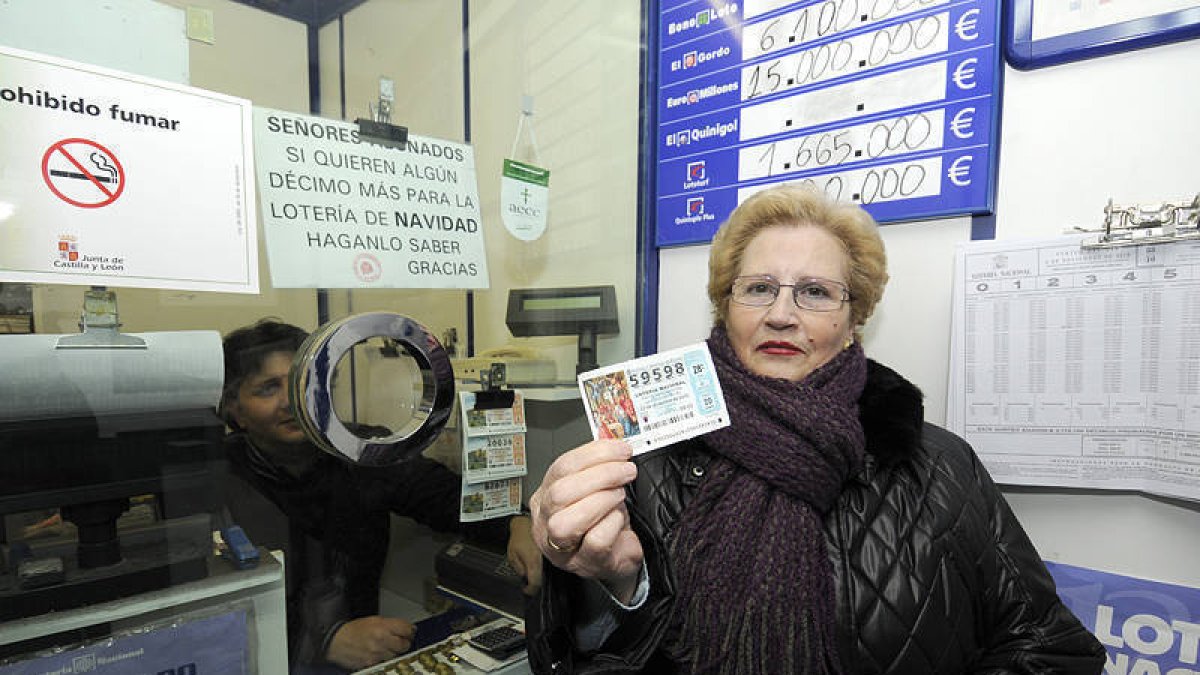 Una mujer muestra ayer un décimo de lotería en una administración de la capital soriana. / VALENTÍN GUISANDE-