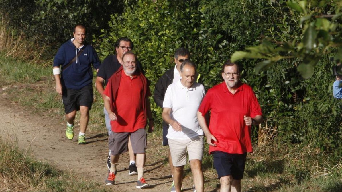 Mariano Rajoy. acompañado por José Benito Suárez (segundo por la derecha), marido de la presidenta del Congreso, Ana Pastor, y unos amigos, en su recorrido por el río Umia, este sábado.-EFE / SALVADOR SAS