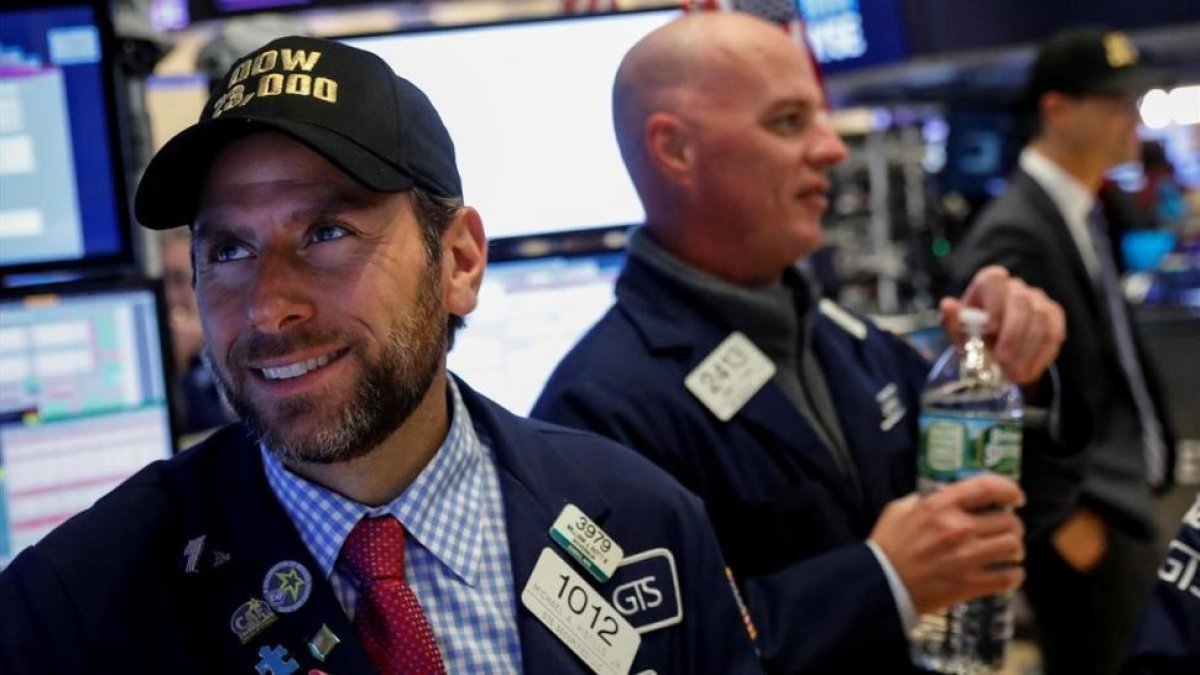 Un operdor de la Bolsa de Nueva York con una gorra conmemorativa de los 23.000 puntos alcanzados.-BRENDAN MCDERMID