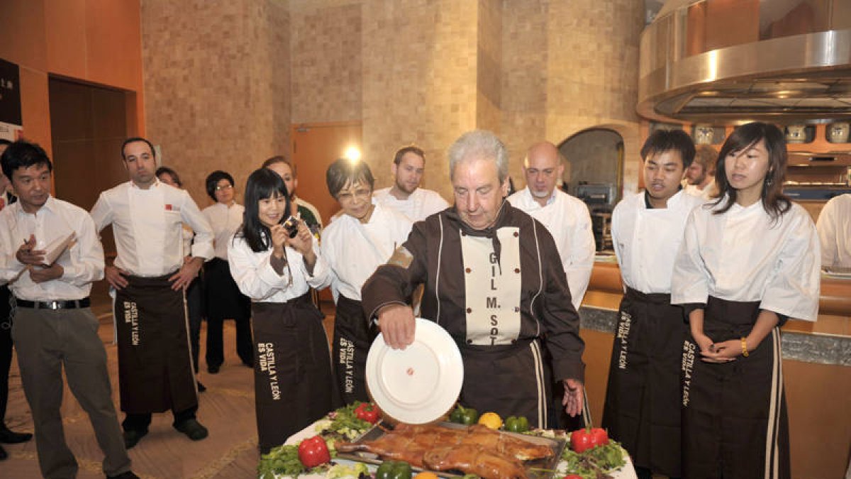 Gil Martínez trocea el cochinillo con un plato. / JUNTA-