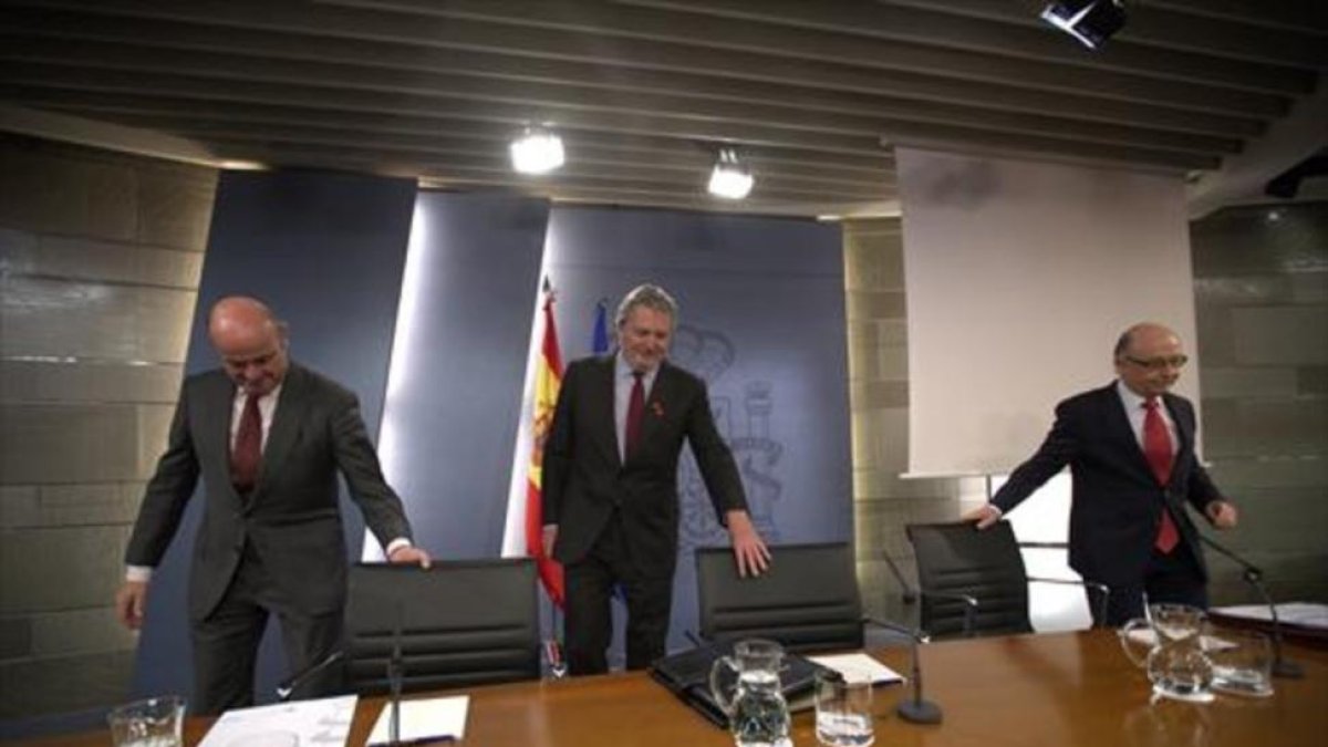 Los ministros Guindos, Méndezde Vigo y Montoro, momentos antes de iniciar la rueda de prensa posterior al Consejo de Ministros de ayer.-DAVID CASTRO