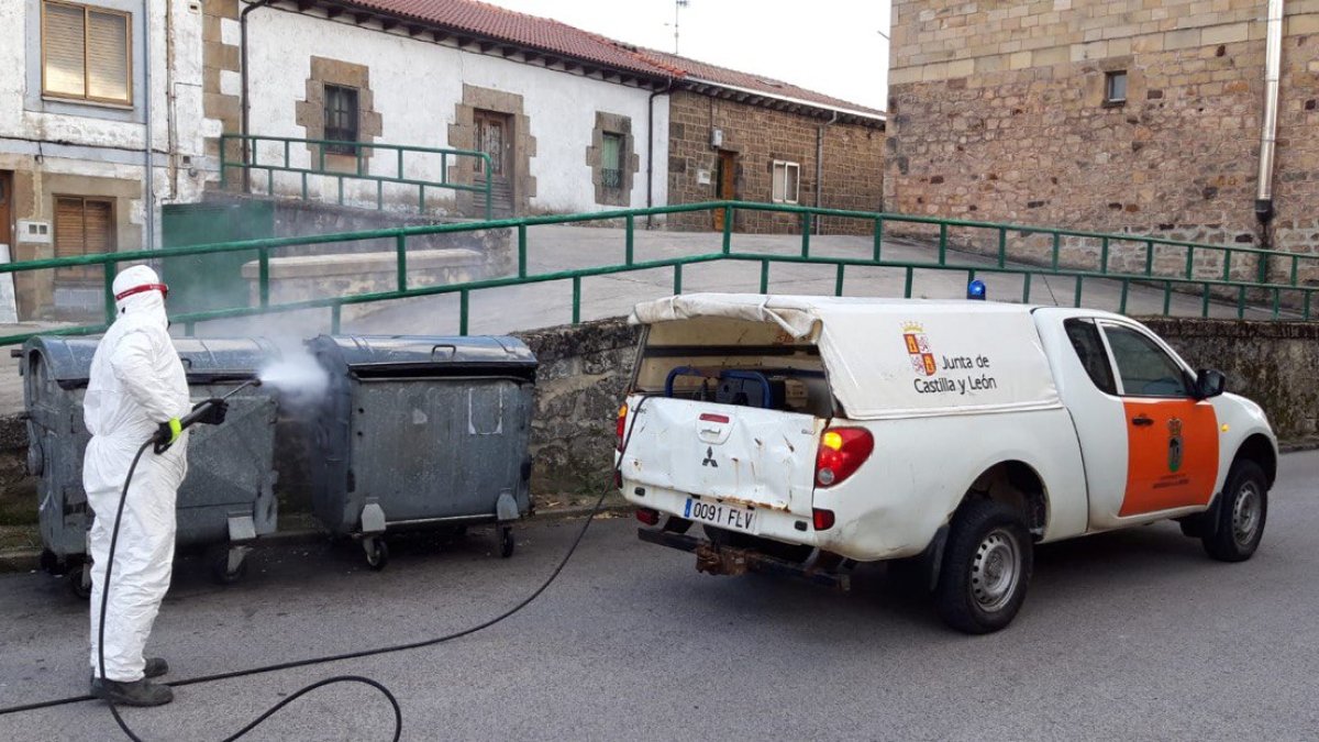 Un operario de la Junta desinfectando contenedores de basura en Quintanar.