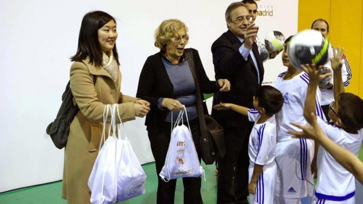 Manuela Carmena, alcaldesa de Madrid, y Florentino Pérez, durante la entrega de obsequios a unos niños.-EFE