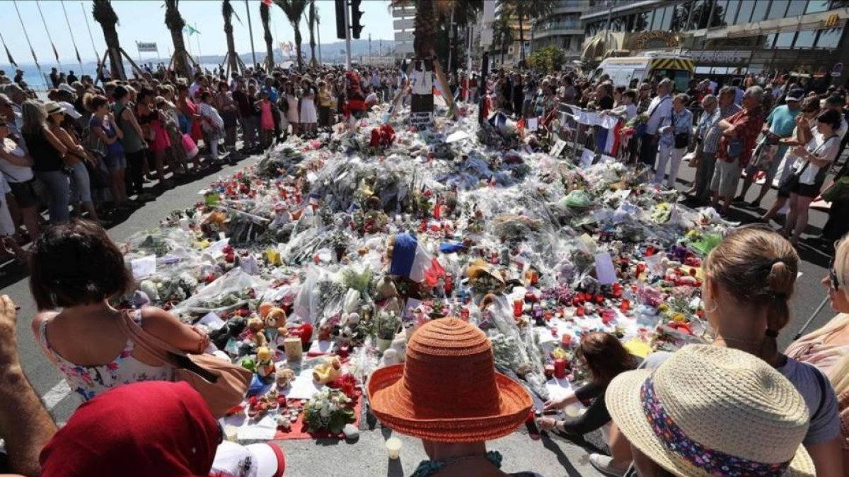 Centenares de personas se reúnen alrededor de las flores situadas en el Paseo de los Ingleses para homenajear a las víctimas-VALERY HACHE
