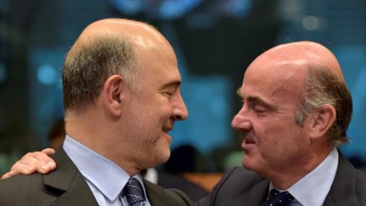 El comisario europeo de Finanzas, Pierre Moscovici, y el español Luis de Guindos, ayer en Bruselas.-REUTERS / ENRIC VIDAL