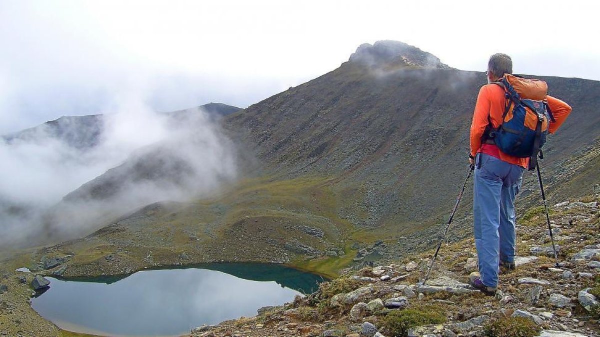 Un montañero observa la Laguna de Urbión desde el Campeón.-NACHO SAEZ