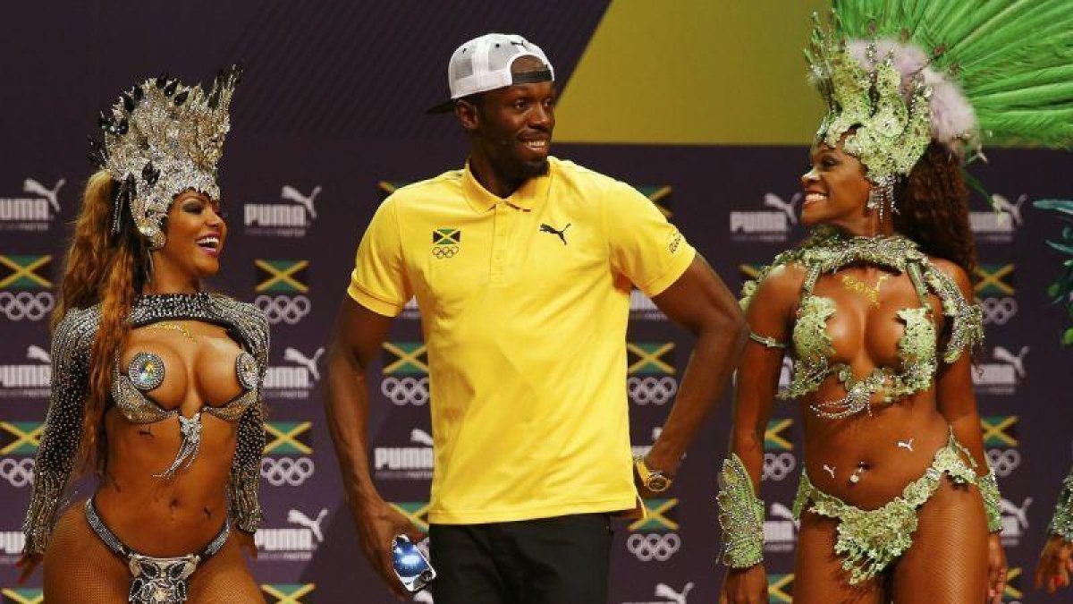Usain Bolt baila samba con unas bailarinas, en la rueda de prensa que dio en Rio este lunes.-REUTERS / NACHO DOCE