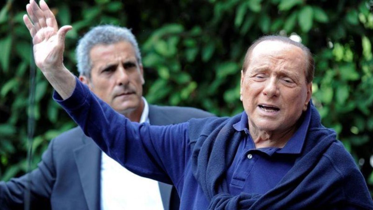 Berlusconi (derecha), al salir del hospital tras operarse del corazón, en Milán, el 5 de julio del 2016.-REUTERS / FLAVIO LO SCALZO