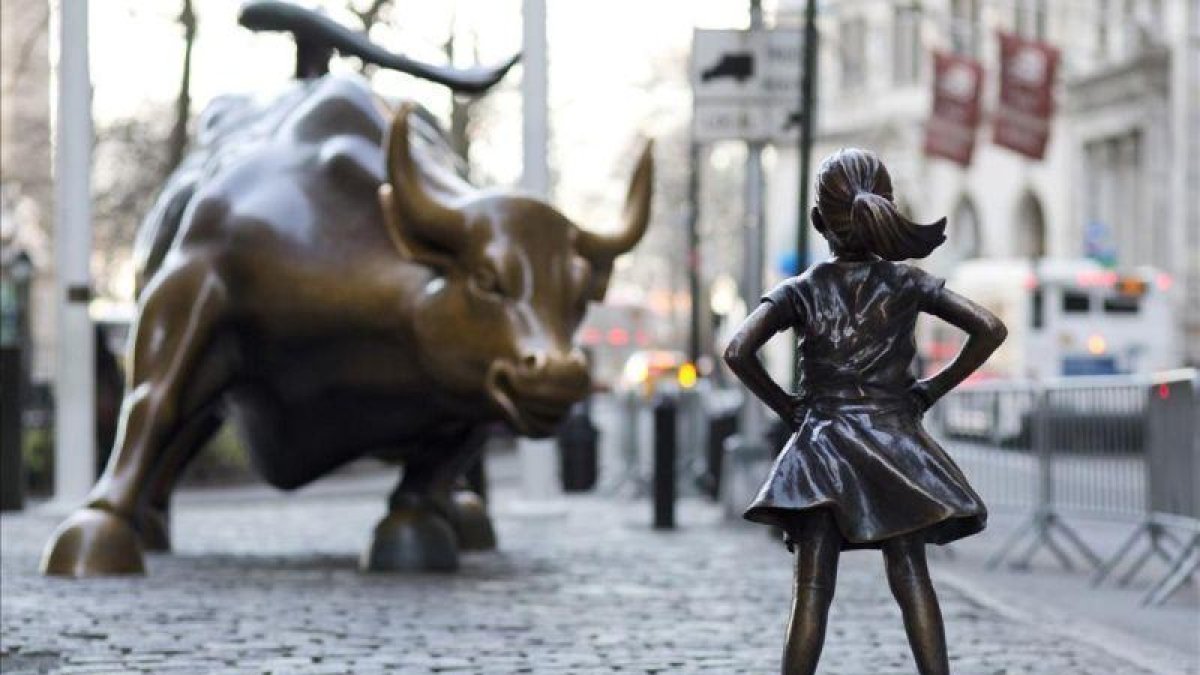 La niña de bronce frente al toro de Wall Street.-AP / MARK LENNIHAN