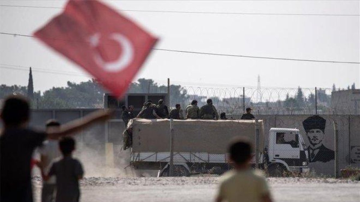 Niños sostienen la bandera de Turquía en el norte de Siria.-EFE