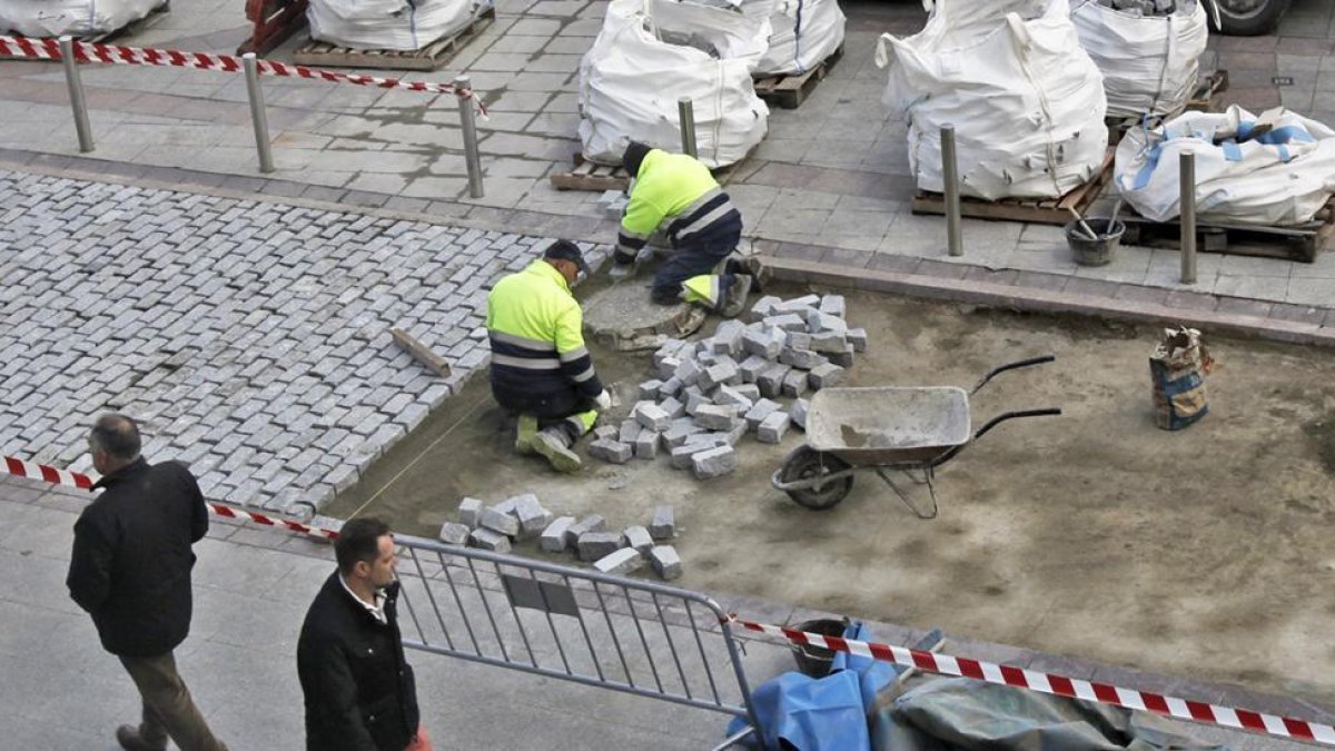 Dos trabajadores en una obra de sustitución de adoquines.