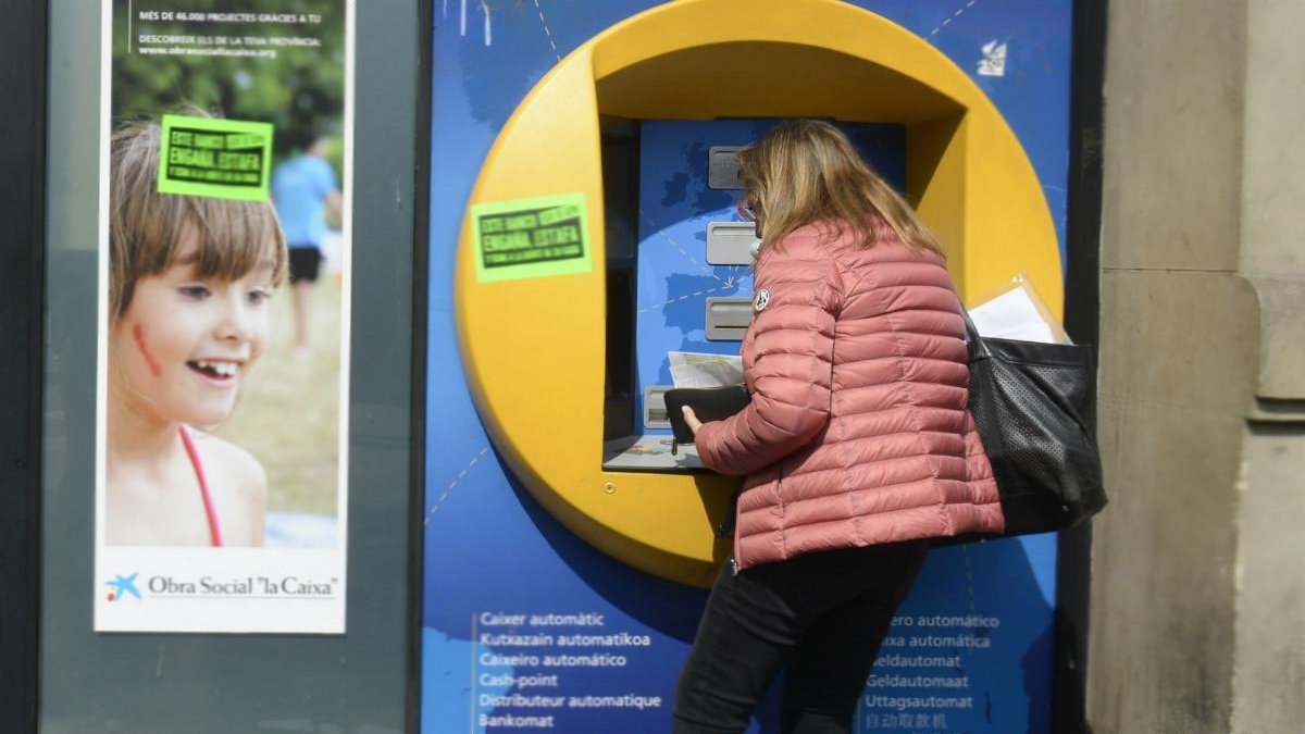 Una mujer saca dinero del cajero automático.-MÓNICA TUDELA