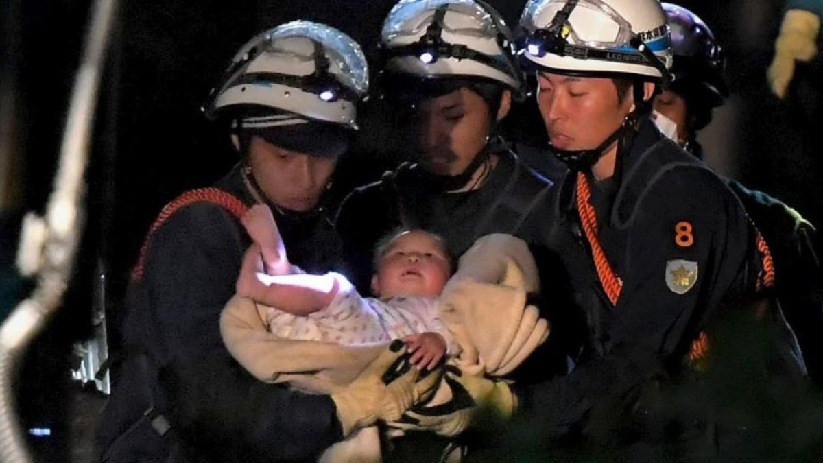 Un bebé de ocho meses rescatado por los trabajadores de emergencias el viernes en Japón.-REUTERS / DAISUKE WADA