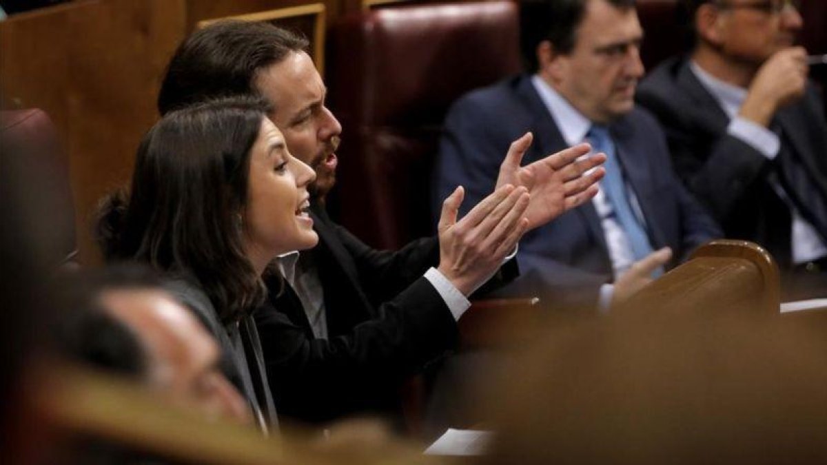 Irene Montero y Pablo Iglesias gesticulan durante la intervención de Soraya Sáenz de Santamaría en la sesión de control.-JOSE LUIS ROCA