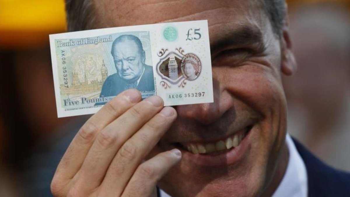 El gobernador del Banco de Inglaterra, Mark Carney, muestra el nuevo billete de plástico de 5 libras.-STEFAN WERMUTH