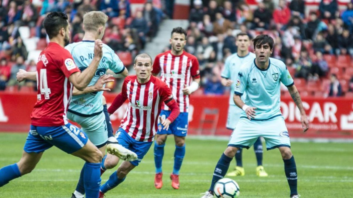 Dani Nieto y Escassi, rodeados de jugadores del Sporting, ayer en El Molinón.-AREA 11