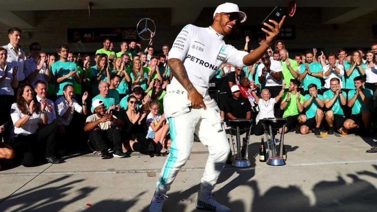 Lewis Hamilton se hace un selfi con su equipo de Mercedes en Austin (EEUU).-AFP / CLIVE ROSE
