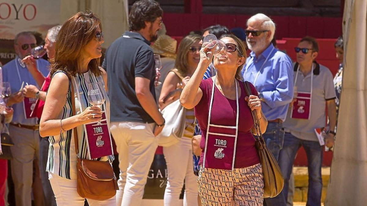 Dos mujeres disfrutan de una copa de vino en la Feria del Vino de Toro.-- ICAL