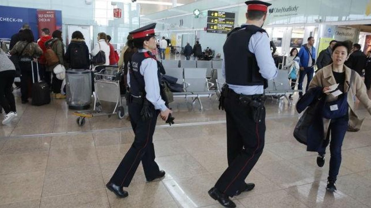 Dos 'mossos' participan en el servicio de vigilancia reforzada del aeropuerto de El Prat.-JOAN PUIG