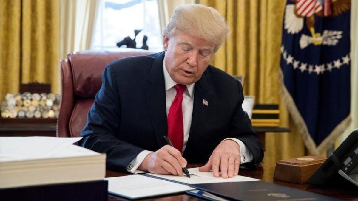 Trump firma la ley sobre la reforma fiscal, en el Despacho Oval de la Casa Blanca, en Washington, el 22 de diciembre.-EFE / MICHAEL REYNOLDS