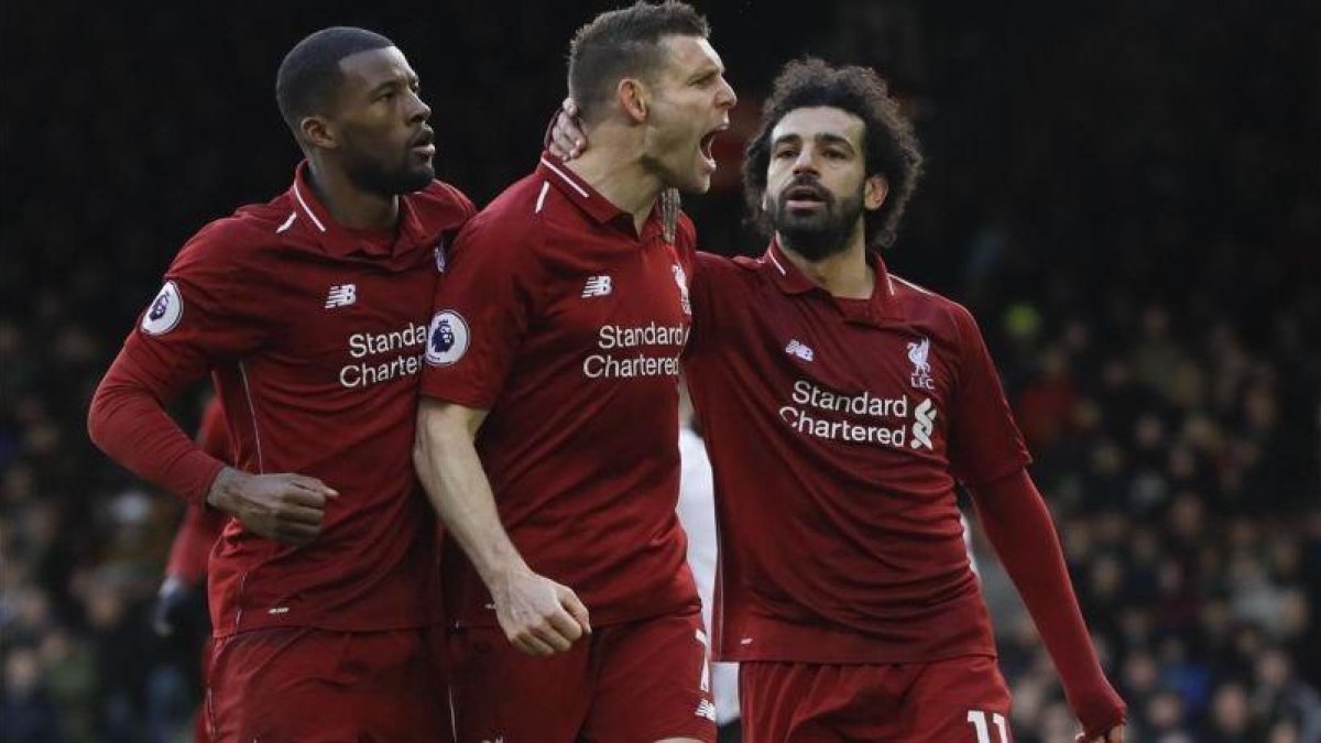 Milner, felicitado por sus compañeros del Liverpool tras marcar de penalti.-EL PERIÓDICO