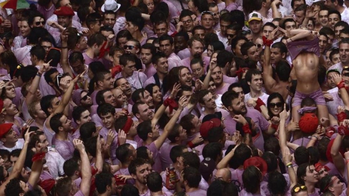 Una joven desnuda su torso en medio del gentío tras el chupinazo de los Sanfermines del 2014.-VINCENT WEST