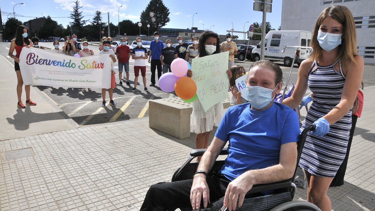 Saturnino Martín, con su hija, a la salida del hospital, donde fue recibido por una veintena de familiares. VALENTÍN GUISANDE