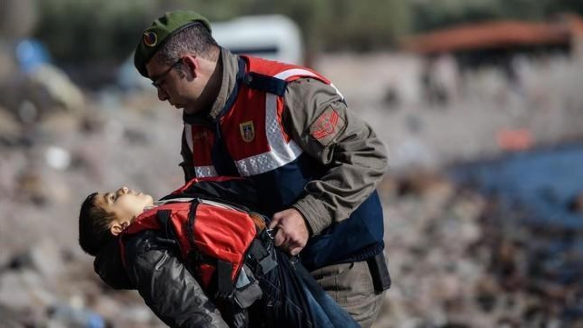 Un policía turco traslada el cuerpo sin vida de un niño tras otro naufragio en el Egeo.-AFP / OZAN KOSE