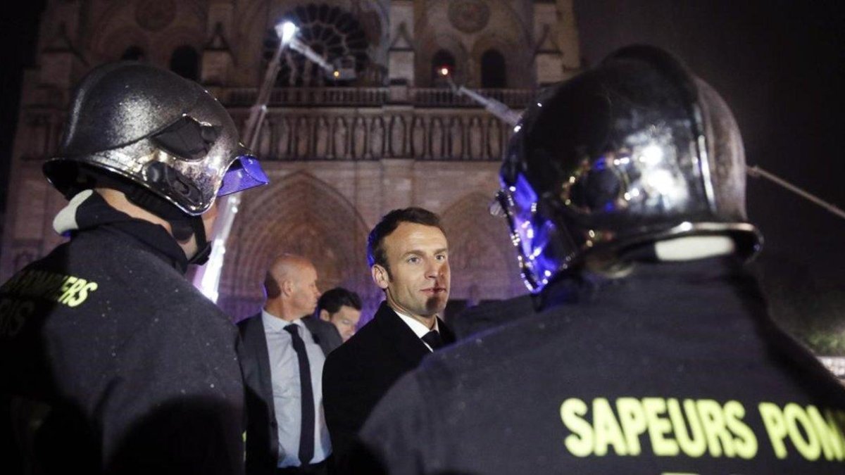 El presidente de Francia  Emmanuel Macron, habla con los bomberos que intentan apagar el incendio en la catedral de Notre Dame, en París, el pasado abril.-EFE