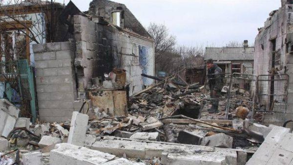 Un rebelde prorruso camina entre edificios destruidos en una calle de Donetsk, este martes.-Foto: EFE / PHOTOMIG