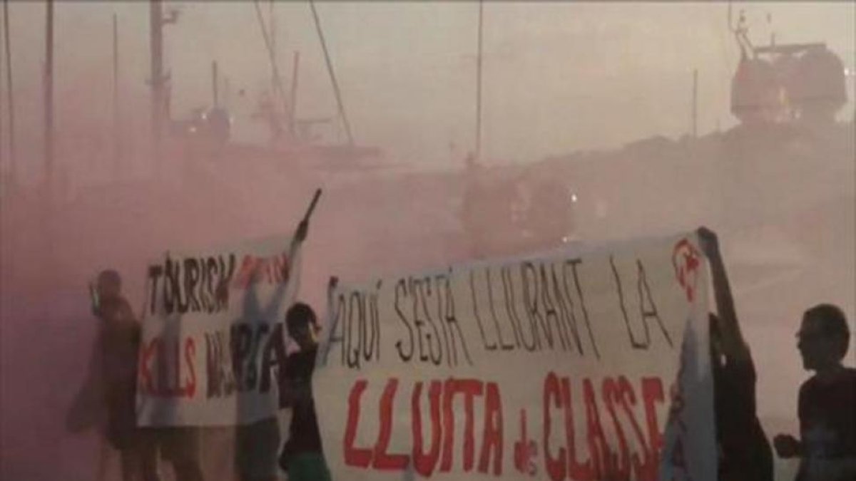 Captura del vídeo distribuido a través de las redes sociales por Arran de una acción contra el turismo con pancartas y bengalas en el puerto deportivo de Palma de Mallorca.-