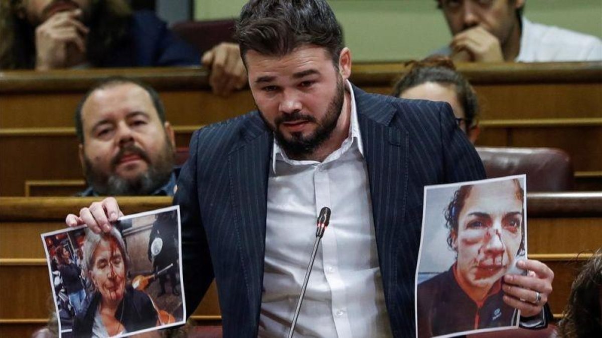 El portavoz de ERC, Gabriel Rufián, muestra unas fotografías al Gobierno.-EMILIO NARANJO/EFE